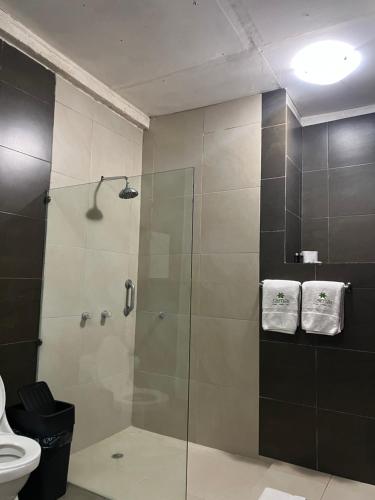 奥隆Samai Lodge Holistic Living的浴室设有玻璃淋浴间和卫生间