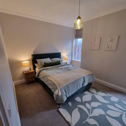 曼彻斯特Apartment 20 min walk from Manchester City Centre的一间卧室配有一张床、两盏灯和一个窗户。