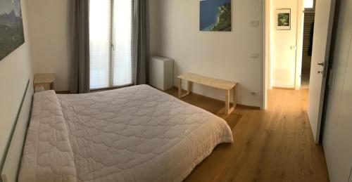 Castion VeroneseCasa betulla的卧室配有白色的床,铺有木地板