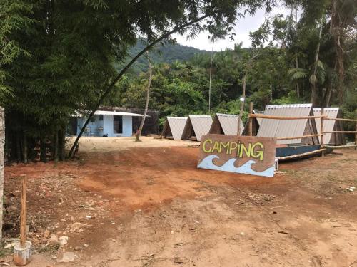 乌巴图巴Camping Toninhas的建筑物前的泥土上的一个标志