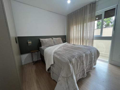 卡内拉REFUGIO SERENO PRÓXIMO A CATEDRAL DE CANELA的一间卧室设有一张大床和一个窗户。