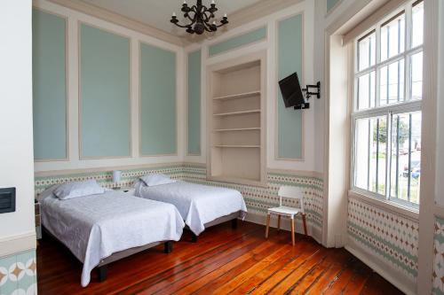 瓦尔帕莱索Casa Baron的一间带两张床的卧室和一台电视