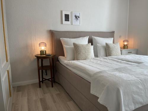 克隆斯加尔德Strandzone 29的卧室配有一张带白色床单和枕头的大床。