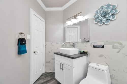 休斯顿Prolific Blue Oasis near Med Ctr Dwntwn Galleria的白色的浴室设有水槽和卫生间。