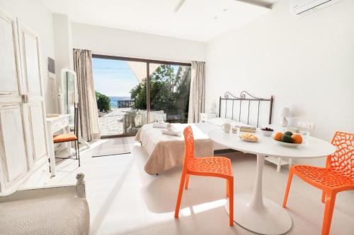 阿齐欧斯·贡多斯Louiza Apartments的白色的客房配有一张床、一张桌子和椅子