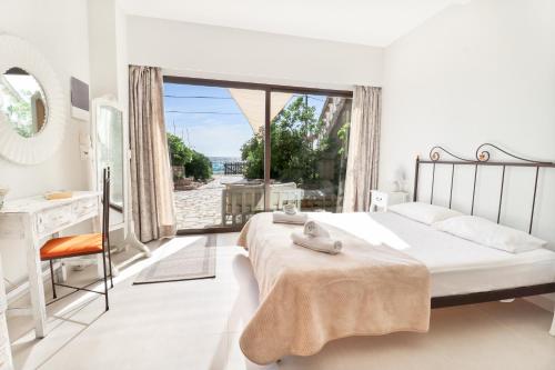 阿齐欧斯·贡多斯Louiza Apartments的白色的卧室设有床和大窗户