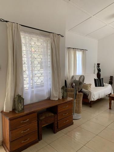 Old YundumBanana Republic的一间卧室配有一张床、一张桌子和一个窗户。