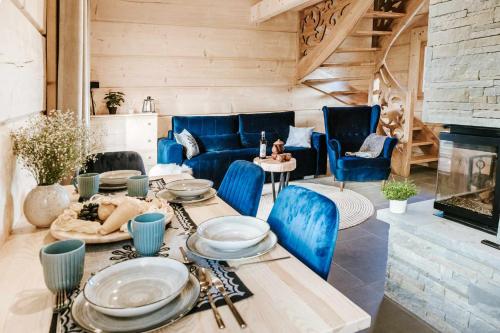 CicheChałpy Pod Ostryszem的客厅配有桌子和蓝色椅子