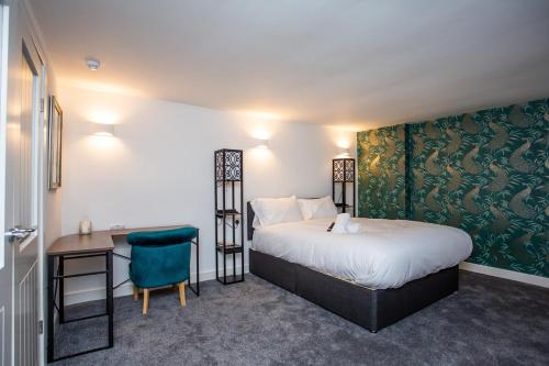 桑德兰Stephenson's Lodge - Stylish One Bed - City Centre的酒店客房配有一张床、一张桌子和一把椅子。