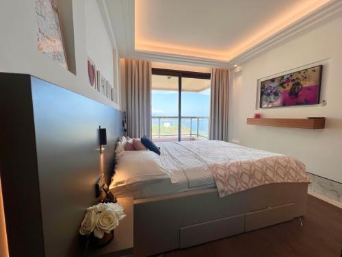 蒙特卡罗Luxury Residence in Prime Monte Carlo的一间卧室设有一张床和一个大窗户