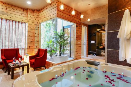 西姆拉西姆拉蜜月酒店的一间带浴缸和两张红色椅子的浴室