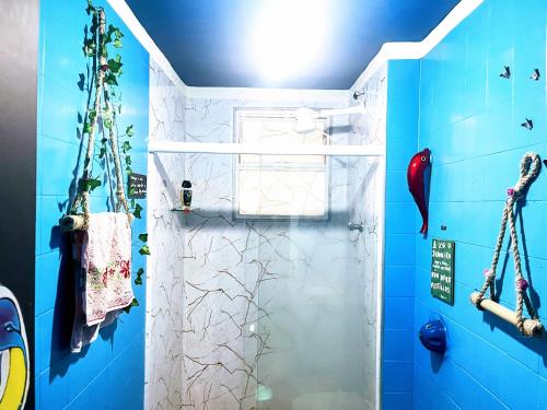 维多利亚Toca da Mona Roots Hostel的带淋浴的浴室(带蓝色墙壁)