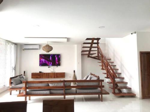 蒙塔尼塔Montañita House, con Piscina Frente al Mar, 25Pers的带沙发和楼梯的客厅