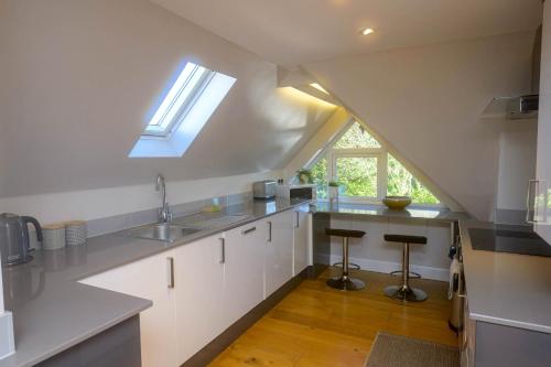 布罗肯赫斯特Entire Apartment in Central Brockenhurst的厨房配有白色橱柜和天窗。