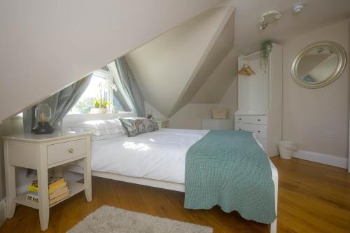 布罗肯赫斯特Entire Apartment in Central Brockenhurst的卧室配有白色的床和窗户。