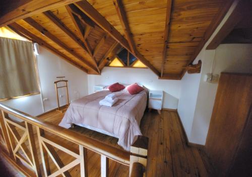 乌斯怀亚La Barranca的一间带一张床的卧室,位于带木制天花板的房间内