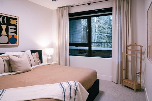 雷夫尔斯托克Snow & Swing Getaway - Three Bedrooms with Hot Tub (Stay Revy)的一间卧室设有一张大床和一个窗户。