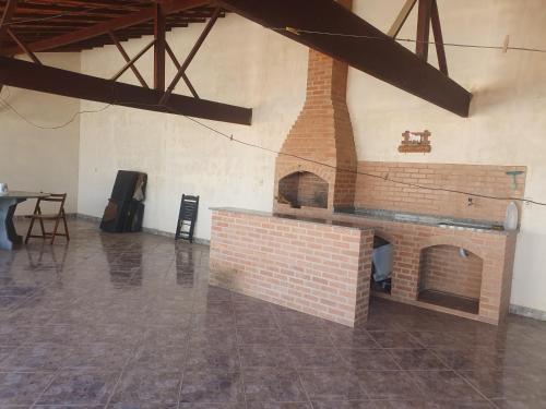 IpitangasCasa temporada da Nenê的一间设有桌子的客房内的砖砌壁炉