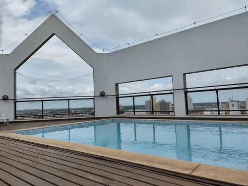 坎普斯戈伊塔卡济斯Apto confortável, acolhedor e bem localizado的一座带窗户的建筑的顶部游泳池