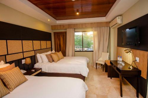 奇特雷Hotel Faranda Guayacanes, a member of Radisson Individuals的酒店客房设有两张床和电视。