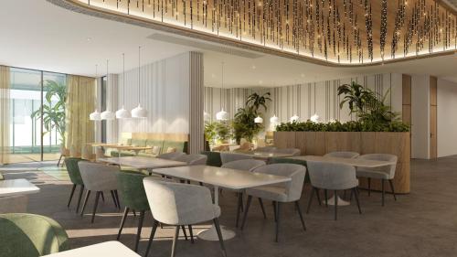 迪拜Staybridge Suites Dubai Business Bay, an IHG Hotel的一间设有桌椅的餐厅,种植了植物