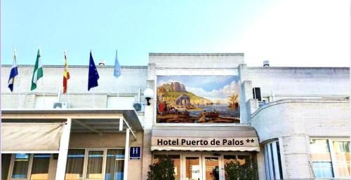帕洛斯德拉夫龙特拉Hotel Puerto de Palos (La Rabida)的一面挂着旗帜的建筑的壁画