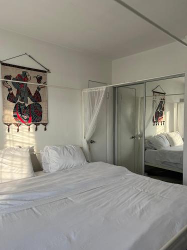 洛杉矶Laurel house weho historic district的卧室配有一张白色大床和镜子