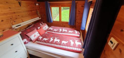 Kleine Blockhütte im Garten的小木屋内的一张床位,配有枕头