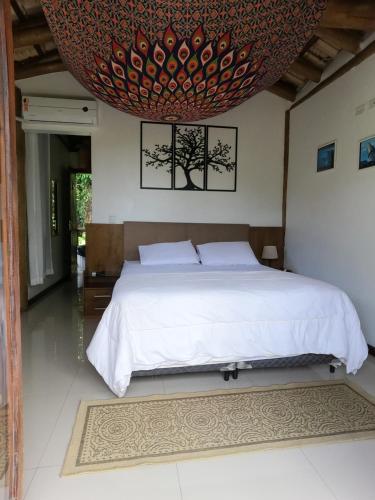 乌巴图巴Chalé e Suite Manacá的一间卧室设有一张大床和大型天花板
