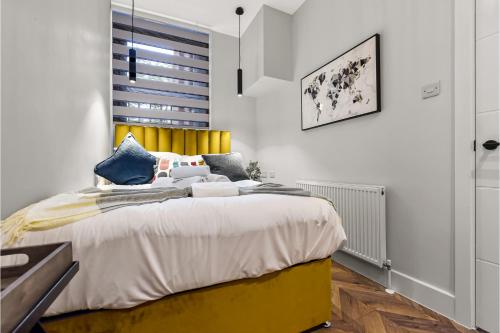 伦敦Lovely 2 BR with Grill的一间卧室配有一张带黄色床头板的大床