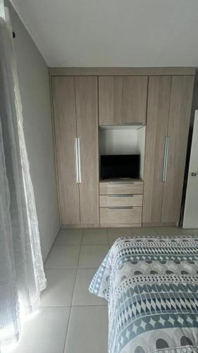皮拉伊河畔巴拉Flat Aldeia Das Águas Village的一间卧室配有一张床和木制橱柜