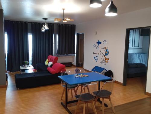 云顶高原10Pax Deluxe Apartment , CloudView Snoopy Theme, Amber Court, Genting Highlands的客厅配有蓝色桌子和沙发