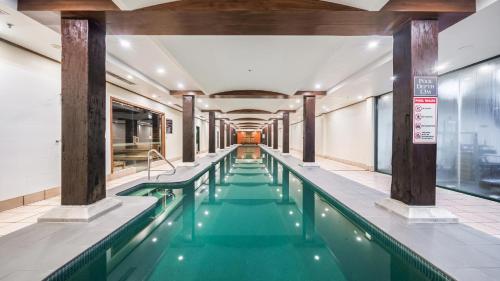 悉尼Oaks Sydney Goldsbrough Suites的一座绿色的游泳池,位于一座建筑中