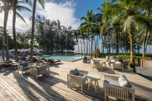 功孟海滩Dusit Thani Krabi Beach Resort - SHA Extra Plus的一个带游泳池、椅子和棕榈树的度假村