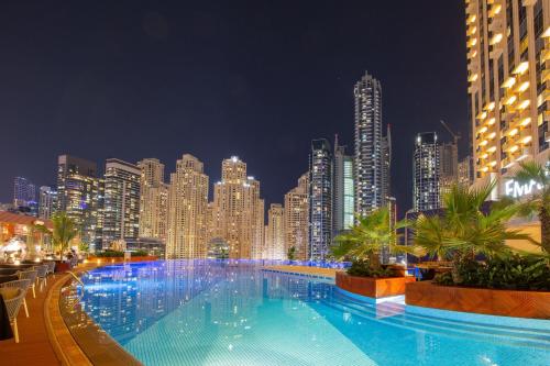 迪拜JW Marriott Hotel Marina的一座在晚上拥有城市天际线的大型游泳池