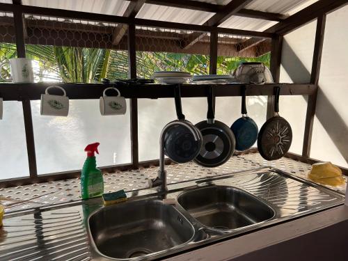 TiputaRangiroa Bliss的厨房水槽上挂着锅碗瓢盆