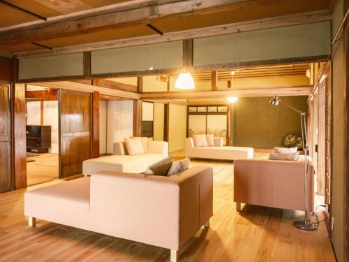 白马村古民家ホテル 結 YUWAI的一间带两张床和一张沙发的客厅