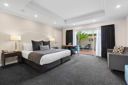 本迪戈本迪戈全季度假酒店的一间卧室配有一张床、一张桌子和一张沙发