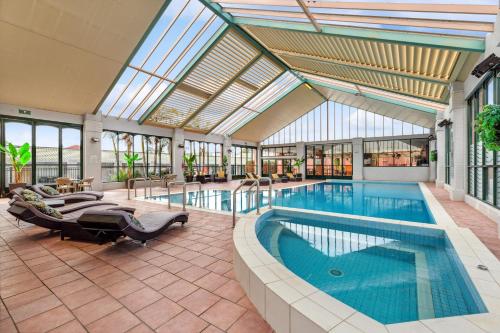 本迪戈本迪戈全季度假酒店的一座带大型玻璃天花板的建筑中的游泳池