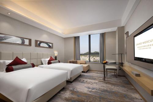 济南济南阳光壹佰雅高美爵酒店的酒店客房设有两张床和一台平面电视。