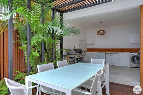 圣丹尼斯Ti Kaz Bellevue - villa avec vue mer - jacuzzi - Saint-Denis的厨房配有蓝色的桌子和白色的椅子