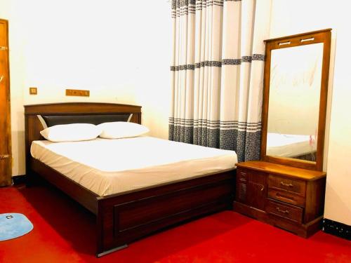 波隆纳鲁沃R & D Resort的一间卧室配有一张带镜子和梳妆台的床