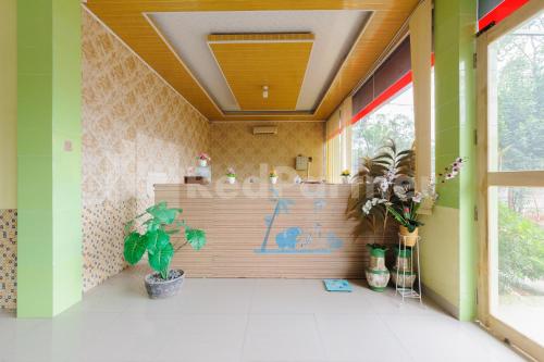 NegarasakaHomestay Hj Suharti Natar Lampung RedPartner的一间有植物柜台的房间