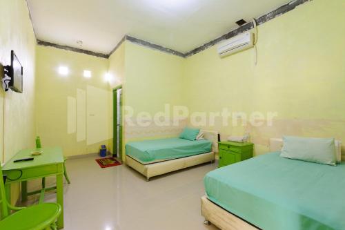 NegarasakaHomestay Hj Suharti Natar Lampung RedPartner的一间医院间,配有两张床和一张书桌