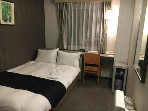 鸟取市Tottori City Hotel / Vacation STAY 81346的配有一张床和一张书桌的酒店客房