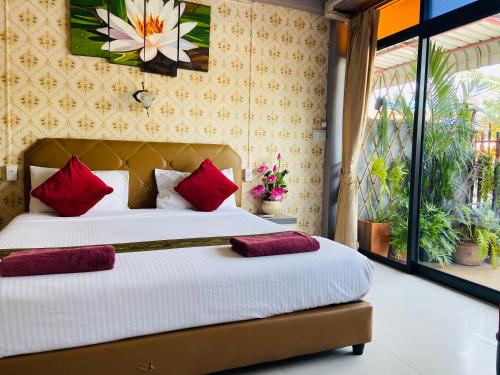 大城Casa Krung Kao的一间卧室配有一张带红色枕头的大床