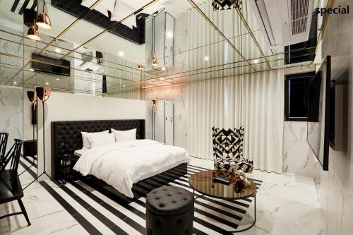 首尔艺术家驿三汽车旅馆的卧室配有1张床、1张桌子和1把椅子