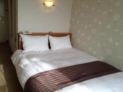 鸟取市Tottori City Hotel / Vacation STAY 81348的一张带白色床单和枕头的床