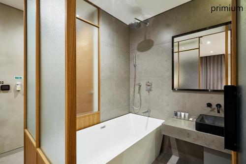 首尔艺术家驿三汽车旅馆的带浴缸、水槽和镜子的浴室
