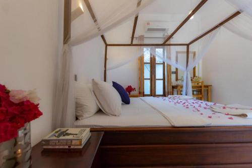 阿鲁甘湾Chimaca Bay Hotel的一间卧室配有一张带天蓬的床